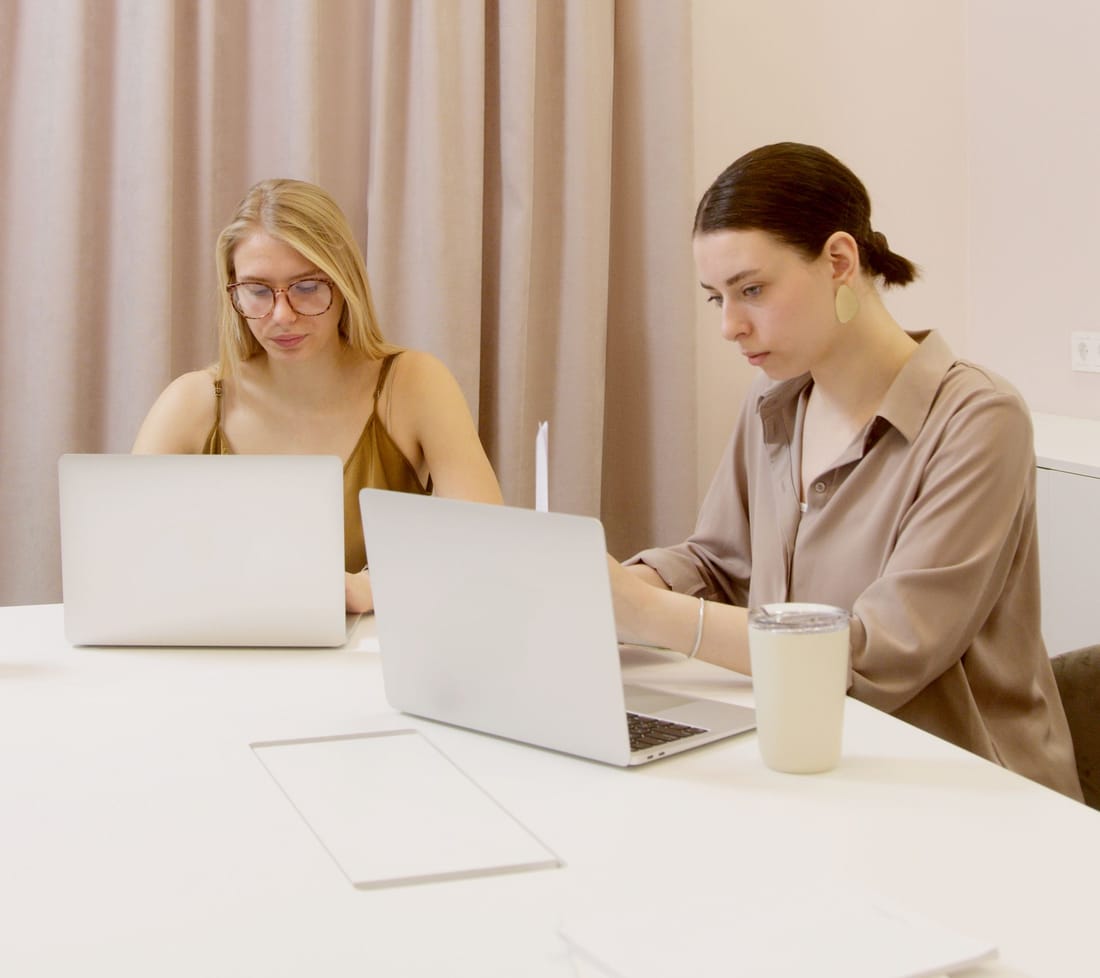 Dos profesionales del equipo de Monday trabajando juntos